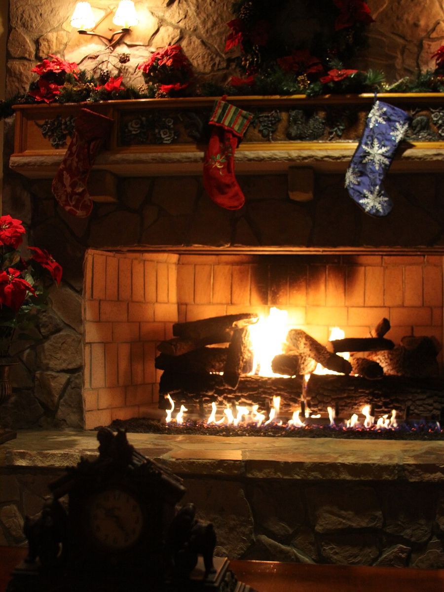 Christmas stockings hung above a glowing fireplace
